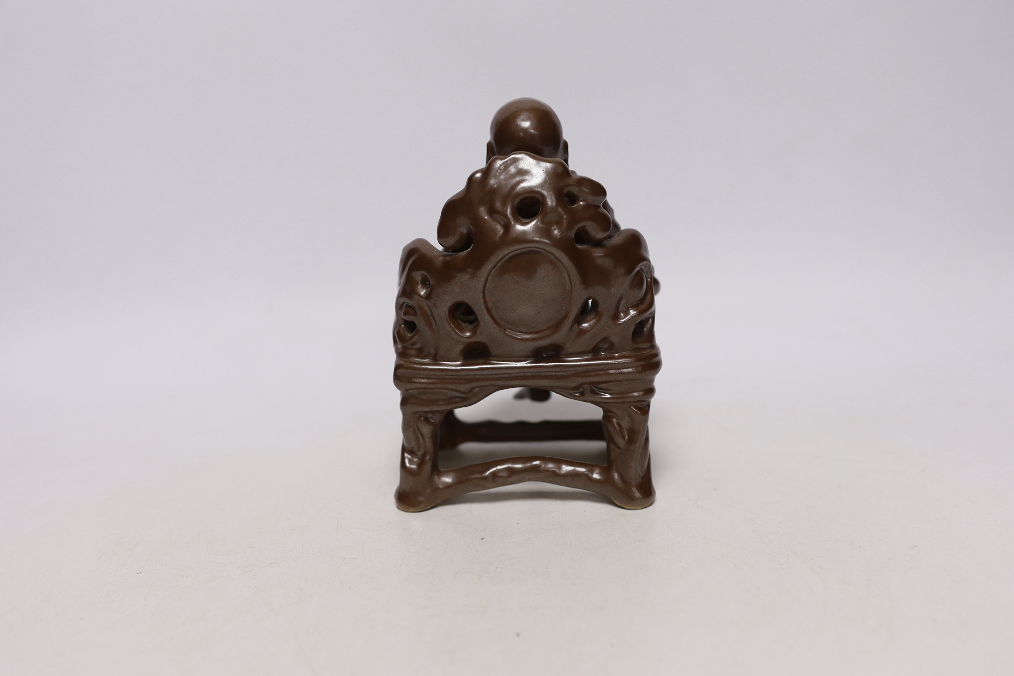 A late 19th/ early 20th century Chinese porcelain faux bronze figure of Budai seated on a throne, 15cm high, Provenance - Owned by the same family prior to 1980.